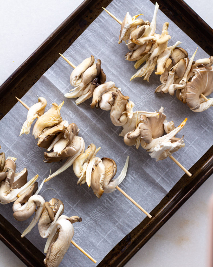oyster mushrooms on a stick on a baking sheet