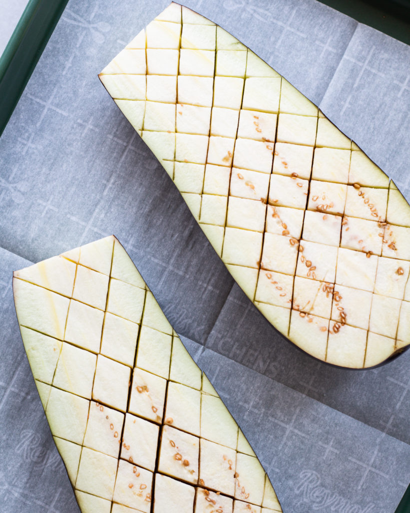Scored eggplant on baking sheet