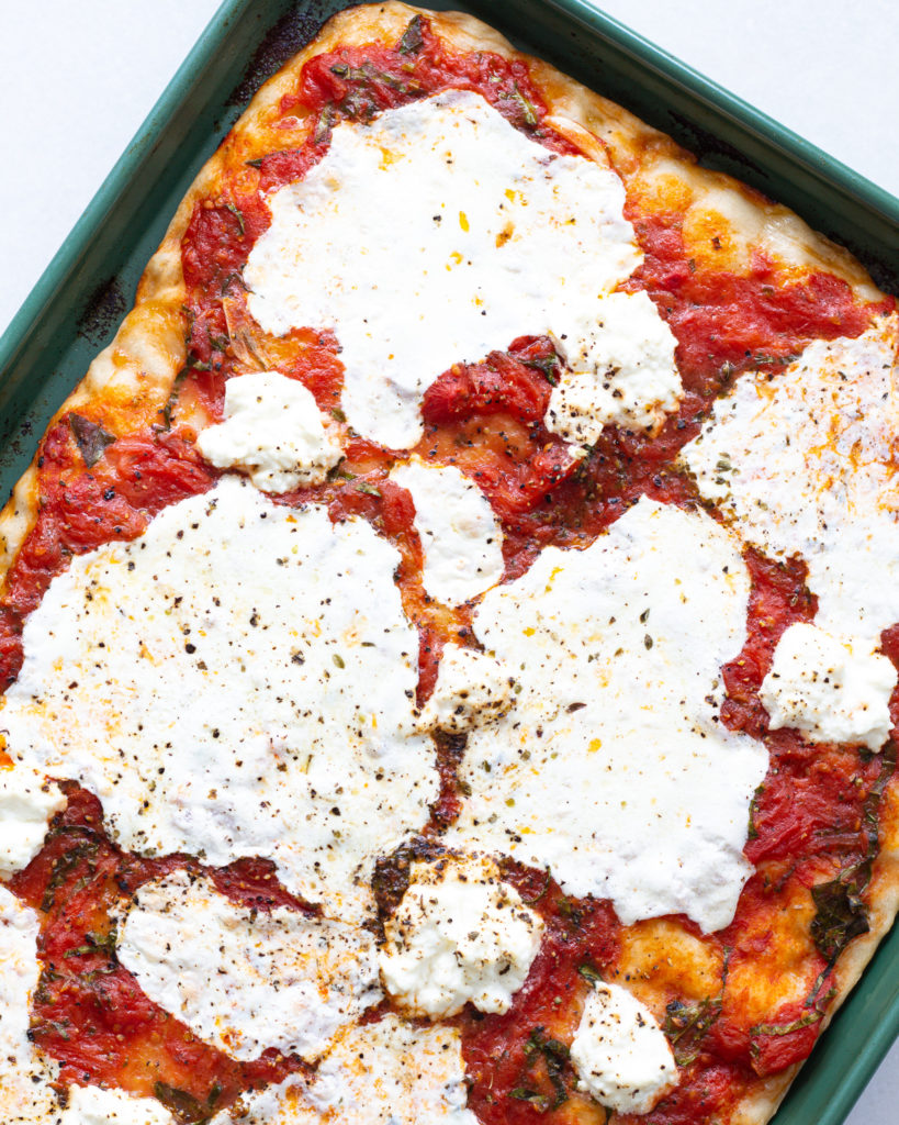 Pizza sauce baked onto a pizza with mozzarella