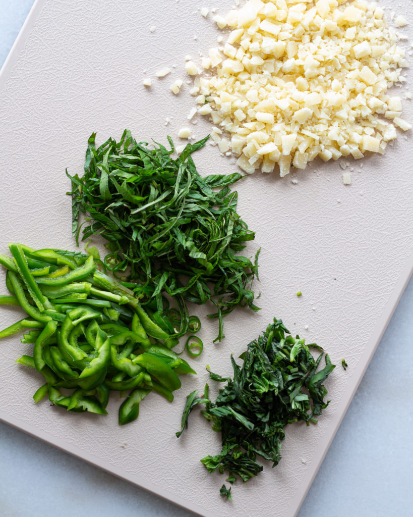 Grated parmesan, and sliced mint, basil, chilies and bell pepper
