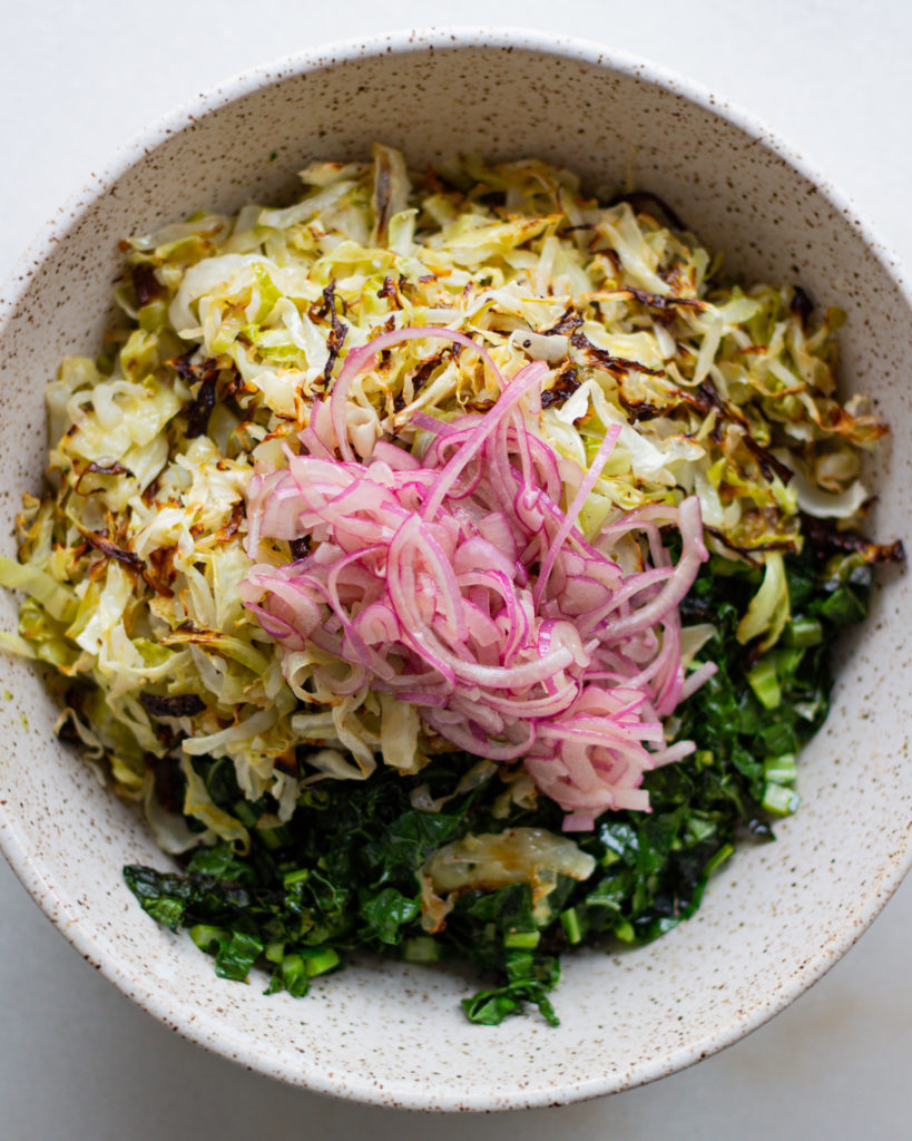 Pickled red onions added to cabbage and kale