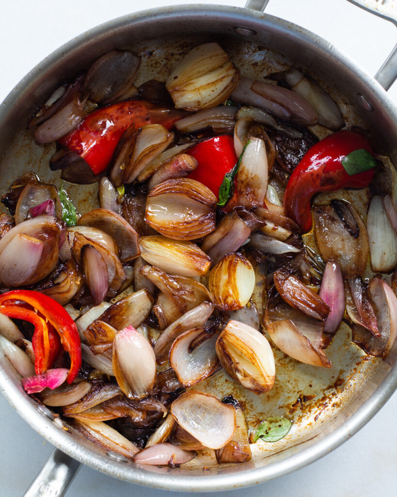 Shallots and peppers cooking in pan