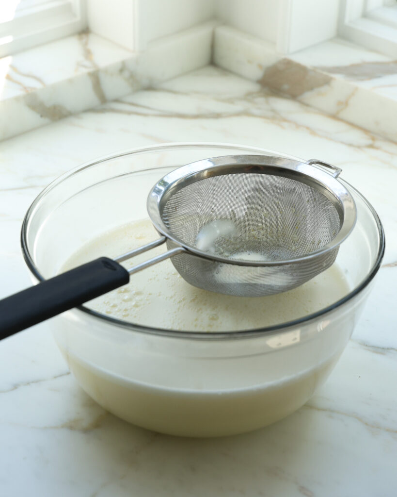 straining out an ice cream base for zucchini ice cream