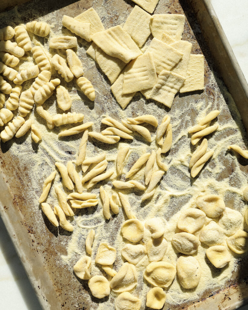 homemade pasta on a baking sheet dusted with semolina flour.