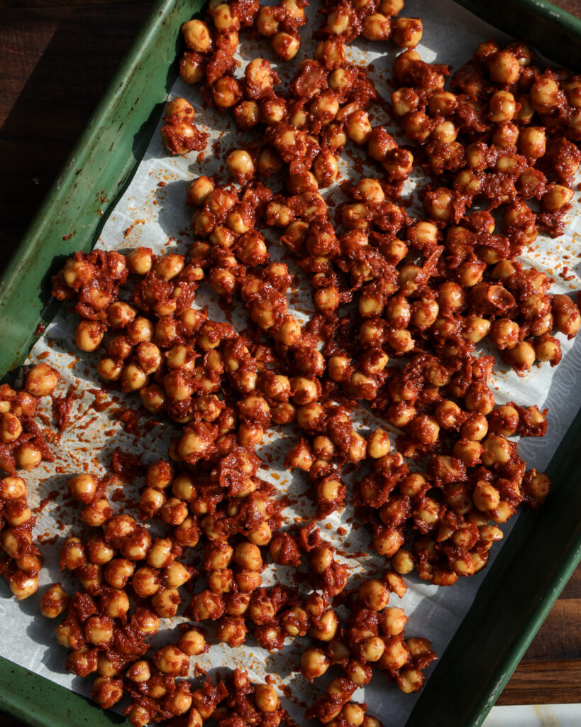 Spiced chickpeas on a lined baking sheet.