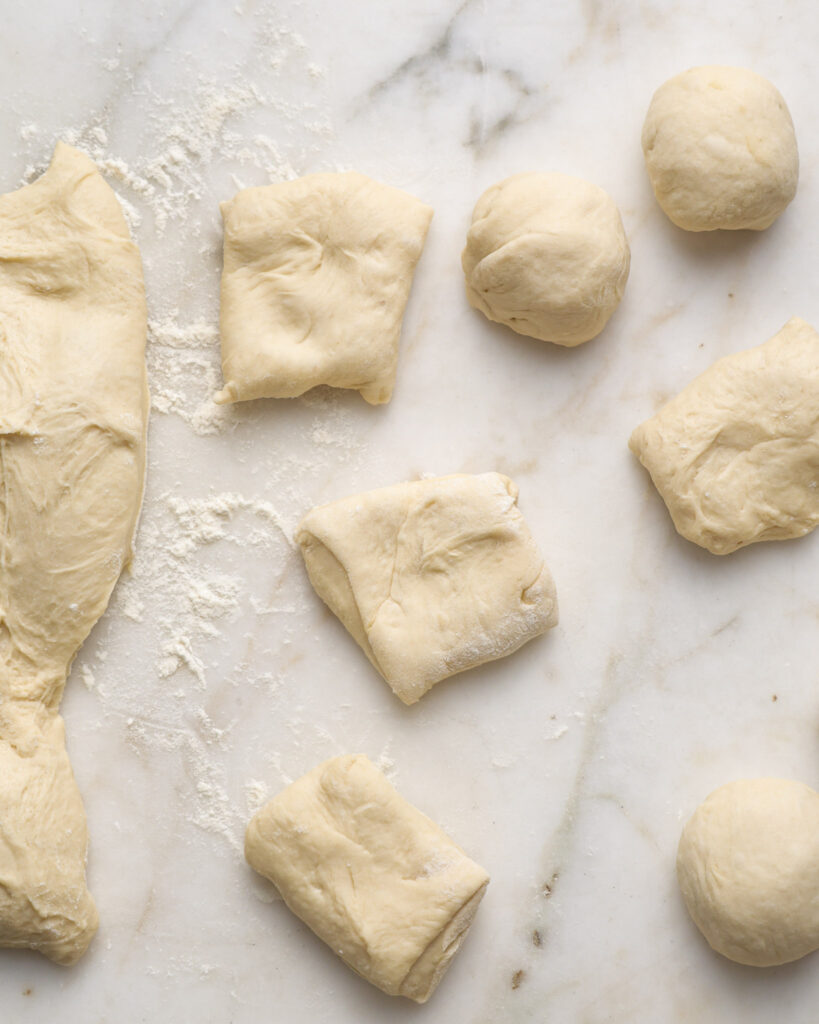 vegan brioche dough being shaped into buns.
