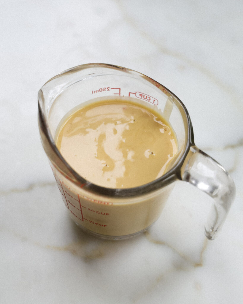 Peanut ginger dressing in a large measuring cup.