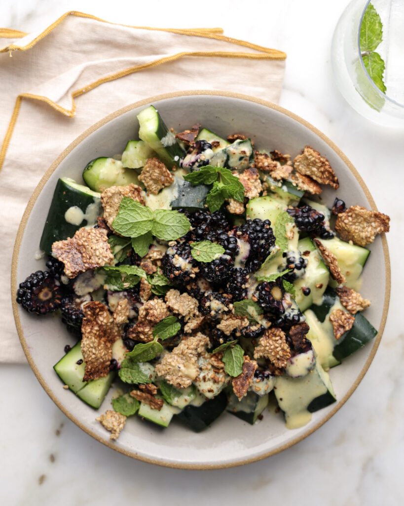 Smashed cucumber and blackberry salad in a bowl.