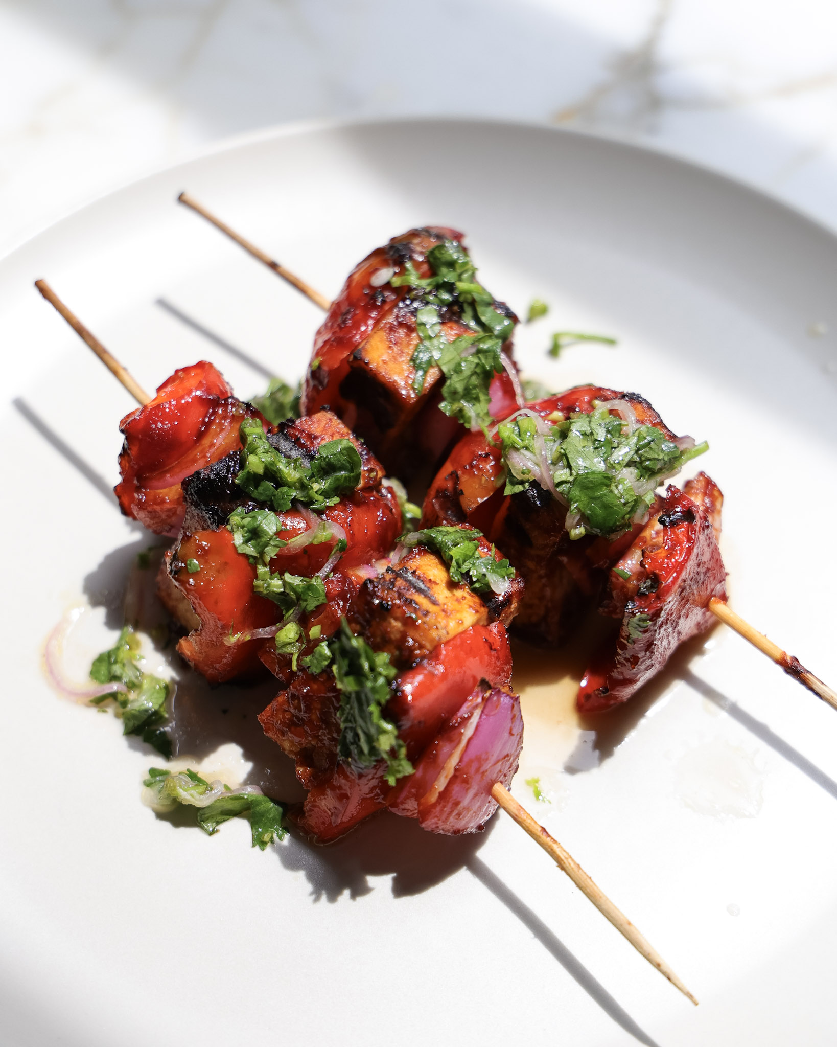 Grilled tofu skewers topped with herb shallot sauce.