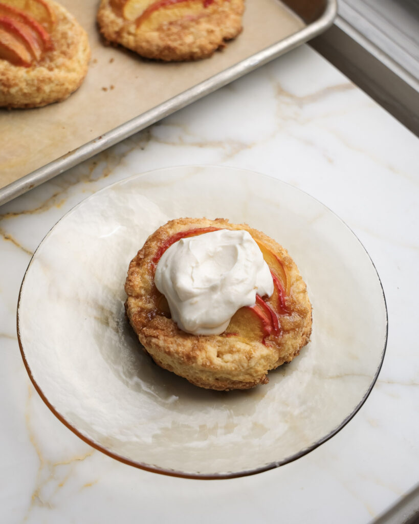 Peach shortcakes topped with whipped cream.
