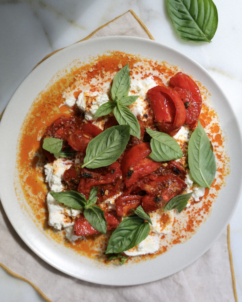 Tomato burrata dip on a plate.