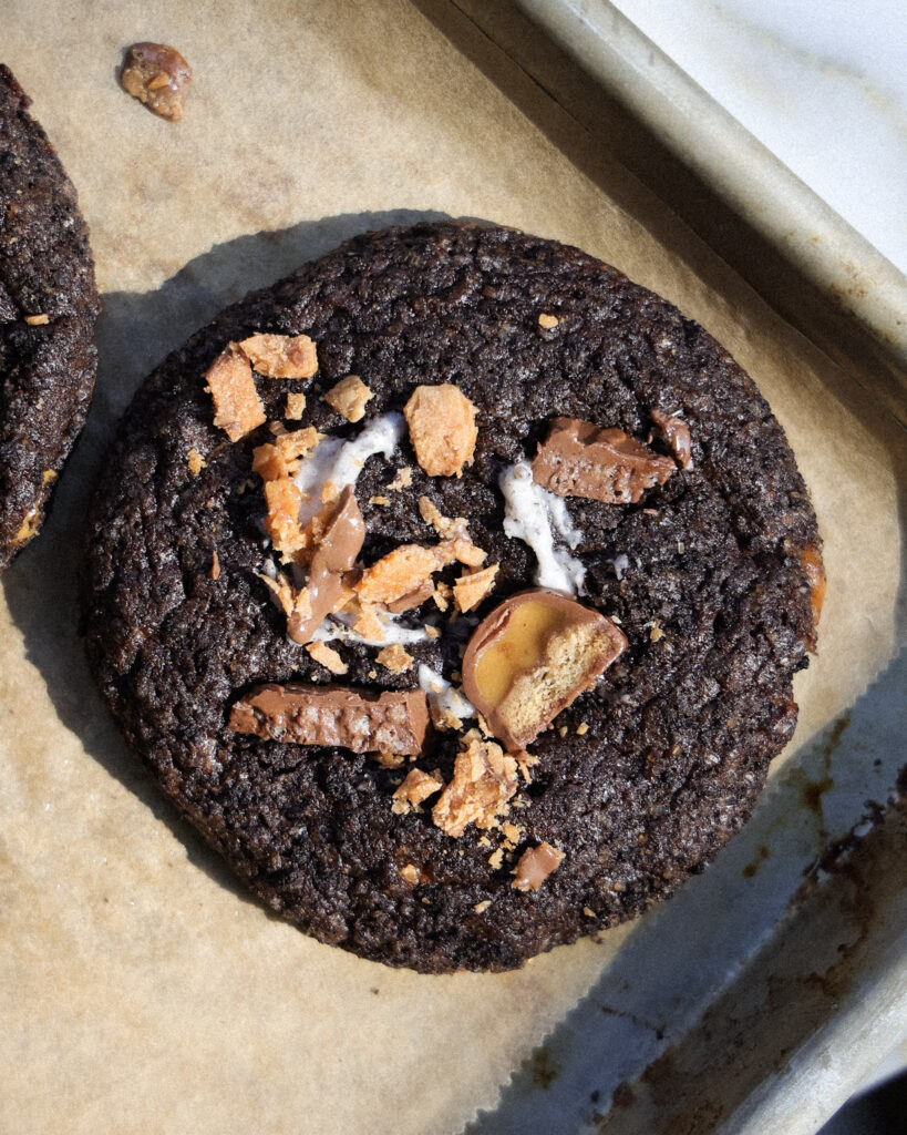 baked death by chocolate cookies on a baking sheet topped with candy.